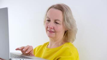 Front view of Caucasian woman using laptop while talking on mobile phone at home video