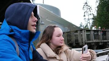 Vancouver Ozeanarium Teenager Kinder Stehen im Jacken auf Straße suchen beim das Telefon Herstellung Videos chatten Ausgaben ihr Teenager Jahre Lernen Über Tiere ein Platz zum Menschen zu entspannen