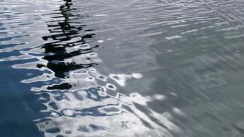 riflessione nel pulito chiaro acqua grigio colore sole leggero raggi di luce del giorno lanterna o pilastro increspature su il mare video