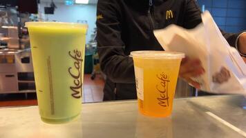 mcdonald's cardápio flores Lugar, colocar para ordem delicioso Eu batido mack café vendedora servindo pacote e dois óculos do batido kiwi e laranja beber Vancouver Canadá 2023 video