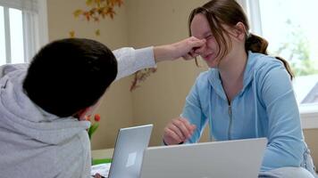 teenagers learn fooling around the boy grabbed the girl by the nose pulls her hand near the computer in the room friends fun spend time together have fun video