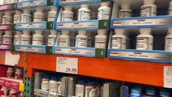 Costco Wholesale Shopping cart vitamins on the shelves the camera slowly floats shooting scenes and various large selection of medicines pharmacy health care nutritional supplements video