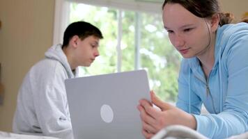 adolescentes hermano y hermana estudiar en línea a colegio sentar en el mismo habitación juntos cerca ordenador portátil en línea conferencia Mira para respuestas en el Internet todos tiene su propio artilugio video