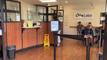 LifeLabs Laboratory for blood tests people stand in line waiting for their tests in the office in the clinic taking live queue record workers masks treatment waiting for the diagnosis sit in lobby video