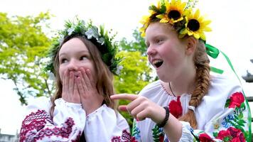 muchachas chismes punto dedos hablando entretenimiento ucranio joven muchachas a fiestas discusión cerca boca con manos espectáculo dedo risa cubrir cara coronas bordado camisas celebracion de ivan Kupala video