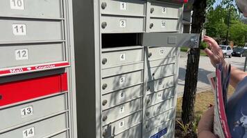 Briefkasten Empfang Briefe kanadisch Frau empfangen Paket im Mail rot Schlüssel von das Box mit Lieferung sie Picks oben Box und wirft Schlüssel im Loch mehrere Videos zum Nachrichten Über Kanada Vancouver surrey 2023