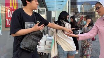 krespy kreme recaudación de fondos Vancouver Canadá 2023 joven asiático personas vender rosquillas en blanco cajas punto a punto el multitud viene en mascaras y sin mascaras escoger a donar video