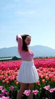 collection of videos and photos where a girl in a white skirt walks through field with tulips blue background sky mountains bright flowering fields teenager young woman walk outdoors beauty self-care