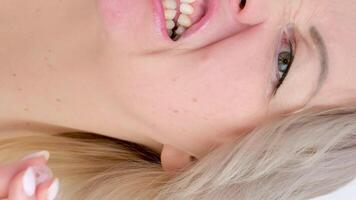 vertikal medelålders blond kvinna åtnjuter mellan en tandborste pensling tänder pensling smuts tar vård av själv tandvård kvinna Söt leende som visar tycka om efter äter dental vård video