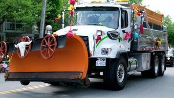 Cloverdale snowplow truck decorated for gay pride weekend celebration with buffalo face ribbons flowers adults people video