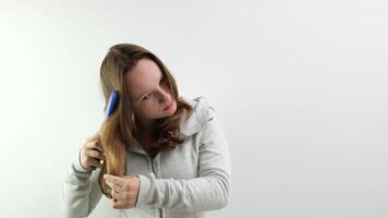 Kämmen Haar mit ein Blau Kamm auf ein Weiß Hintergrund schön gepflegt gesund Haar von ein Teenager Mädchen Jugend jung Körper Ausgezeichnet Shampoos Masken Balsame Schönheit Kugel persönlich Pflege video