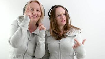 Mutter und Tochter tanzen Welle ihr Index Finger in das Rahmen singen ein Lied mit Kopfhörer Freundschaft von Frauen anders Generationen gut Beziehungen Jugend psychologisch Unterstützung video