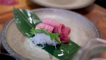 tonijn vis vlees met rijst- vermicelli Aan een vel verspreiding met saus besprenkeld mannetje handen in handschoenen koken in restaurant sushiya slim kijk maar Aan hand- de werkwijze van voorbereidingen treffen een duur schotel Aziatisch keuken video