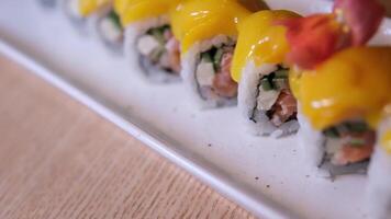 Nahaufnahme, Mango Sushi einstellen auf Weiß Lehm Teller Weiß Hintergrund Mango und Sahne Käse Sushi Geschmack video