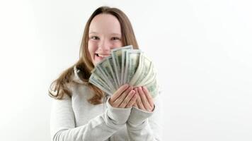 großartig Freude von ein Teenager das zuerst Geld verdient ein Menge von Dollar 100 Dollar Rechnungen ein bündeln ein Mädchen zeigt an Geld im das Rahmen lacht lächelt öffnet ihr Mund mit Freude ein gut Geschenk video