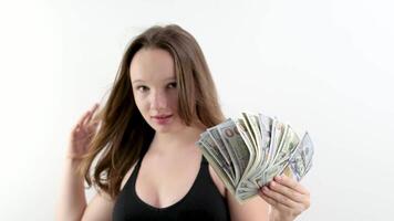 pack of 100 dollar bills in hands of a woman girl is developing in wind on a white background a lot of money for shopping beauty salons are expensive high price money in the wind smile confident look video