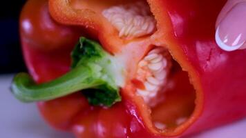 snijdend rijp rood peper, zoet rood peper is besnoeiing in stukken aan de overkant de peper video