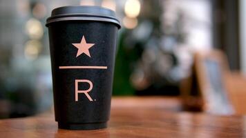 Starbucks Resort black Starbucks cup with star underline big letter R on the table in the coffee shop delicious new coffee luxury famous brand newest video