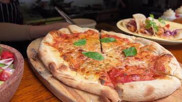 margherita pizza på en sten bakgrund, topp se. pizza margherita med tomater, basilika och mozzarella ost stänger. video