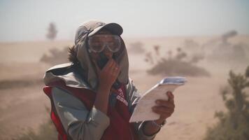 un' ragazza nel il deserto su il impostato di un' film passa qualcosa su il Radio trasmettitore per il. film equipaggio. estremo condizioni di film produzione video