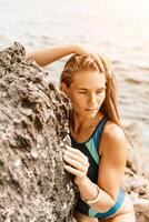 Woman travel summer sea. A happy tourist in a blue bikini enjoying the scenic view of the sea and volcanic mountains while taking pictures to capture the memories of her travel adventure. photo