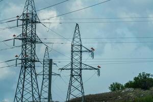 High voltage towers with sky background. Power line support with wires for electricity transmission. High voltage grid tower with wire cable at distribution station. Energy industry, energy saving photo