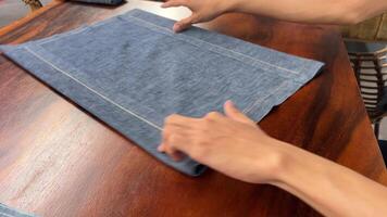 Fold gray cloth napkins Folding new linen dinner napkin on a white wooden table. video