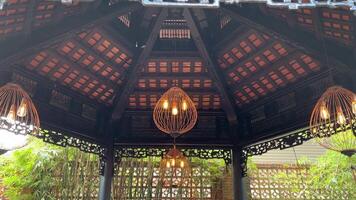 dekorativ Bambus Lampen hängend von das Dach von traditionell indonesisch Holz Haus video