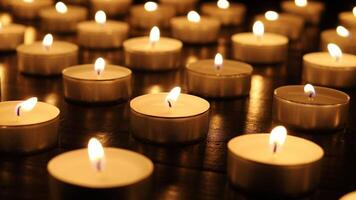 Many burning candles with shallow depth of field. Many small candles on a black background. video