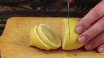 Schneiden ein Zitrone mit ein Messer. Mann Schneiden Zitrone auf Hacken Tafel video