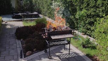brandend hout in achtertuin houtskool grillen. voorbereidingen treffen kolen voor barbecue, kebab. picknick Aan zonnig dag. vakantie en weekend uitjes. video
