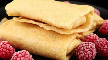 Pancakes with raspberries and nuts on a black plate. healthy breakfast dessert video