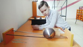 Child looks like a cone rides upward, under the action of the center of mass. Concept of physics. Museum of Science video