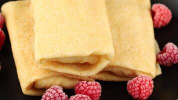 Pancakes with raspberries and nuts on a black plate. healthy breakfast dessert video