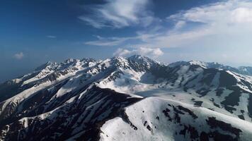 Drone flight through snowy mountain peaks video