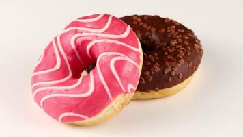 zwei Donuts isoliert. Süßigkeiten und Gebäck Nahansicht. zwei bunt glasiert Donuts video