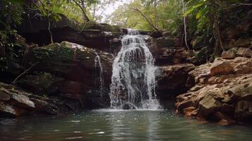 Majestic waterfall cascading down moss-covered rocks into refreshing pool below photo