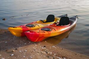 par de vistoso kayaks descansando en el costa, llamando aventureros a explorar oculto calas foto