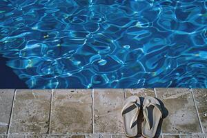 par de chancletas izquierda a el borde de piscina, señalización despreocupado verano día foto