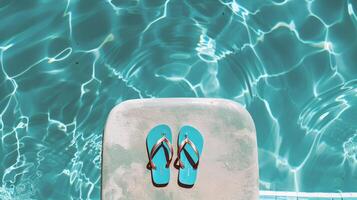 Pair of flip-flops left at the edge of pool, signaling carefree summer day photo