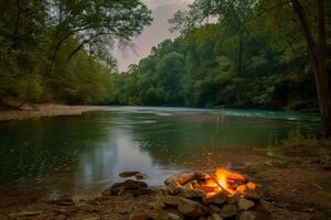 Peaceful riverside campsite illuminated by the flickering light of campfire photo