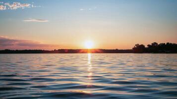 Sunset over tranquil lake, casting warm glow over the water and surrounding landscape photo