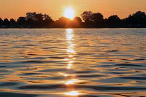 Sunset over tranquil lake, casting warm glow over the water and surrounding landscape photo