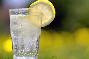 Refreshing glass of lemonade, condensation glistening in the summer heat photo