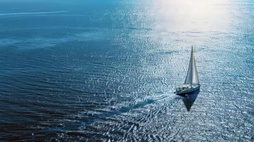 Sailboat gliding across sparkling blue waters, propelled by gentle summer breeze photo