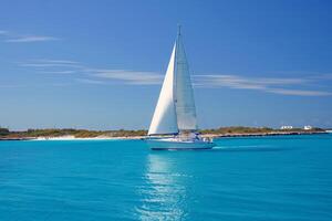 Sailboat gliding across sparkling blue waters, propelled by gentle summer breeze photo