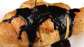 Chocolate poured on croissant close-up. Chocolate with a croissant on a plate. video