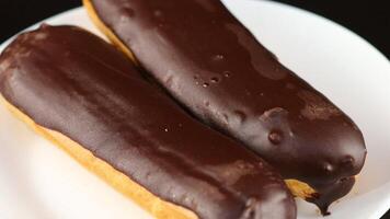 Chocolate eclairs in a white plate close-up. video