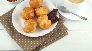Eclairs mit Schokolade, Cappuccino und Milch. Süss Frühstück. Vanille Eclair und ein Tasse von Kaffee video