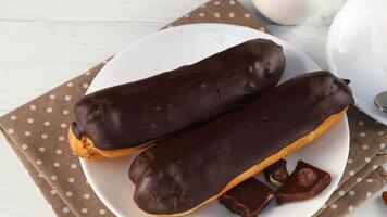 Chocolate eclairs in a white plate close-up. video